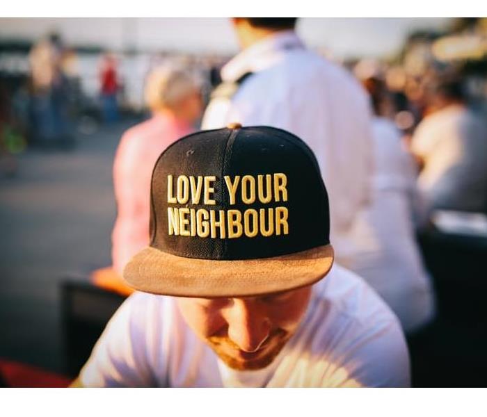Man wearing a hat that says “love your neighbor”